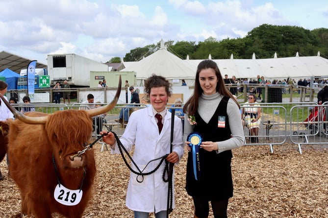 Milly Bradley with winning cow Ailbhe. Judge Lottie Hill, right